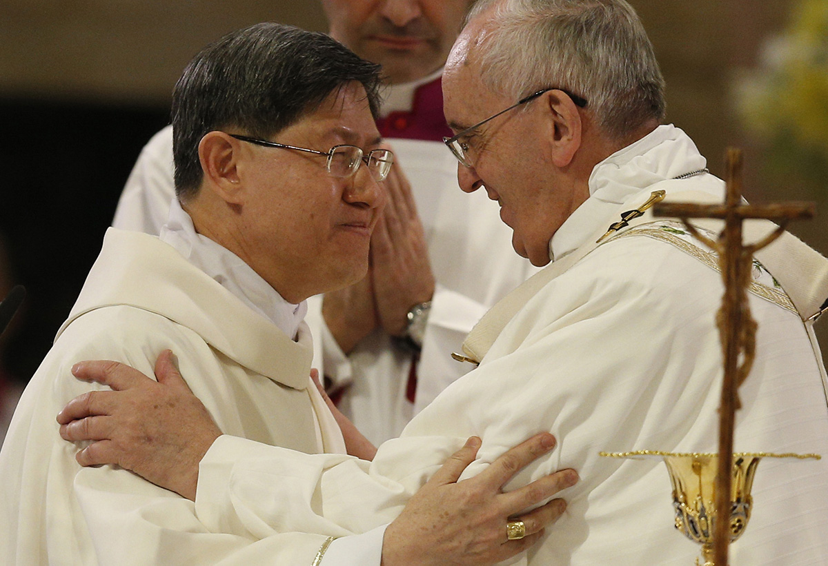 Pope Francis greets Cardinal Luis Antonio Tagle of Manila, Philippines, at the sign of peace while celebrating Mass at the city's Cathedral of the Immaculate Conception 