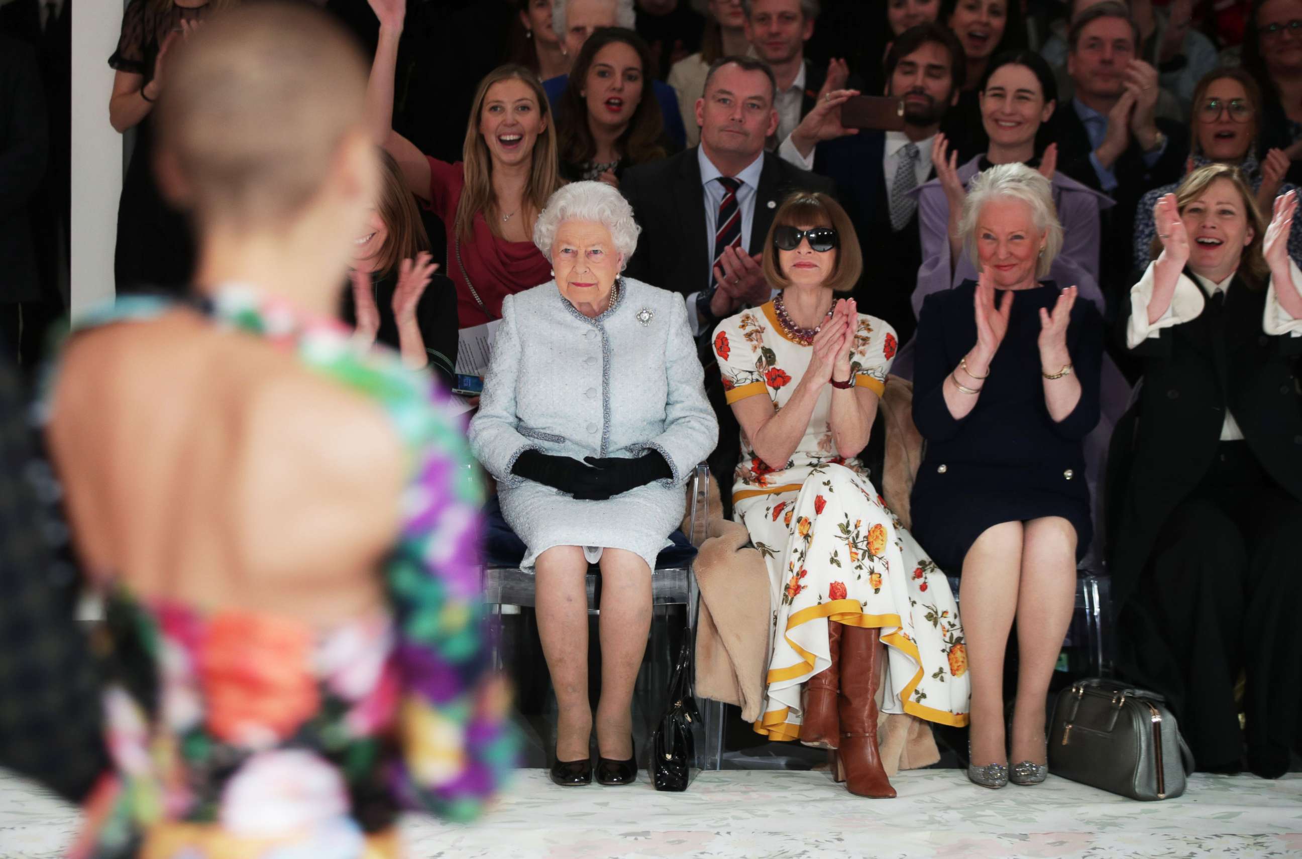 Queen Elizabeth II, accompanied by Anna Wintour and royal dressmaker Angela Kelly, (2R), views British designer Richard Quinn's runway show before presenting him with the inaugural Queen Elizabeth II Award for British Design, during her visit to London Fashion Week's BFC Show Space in central London, Feb. 20, 2018.